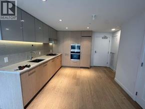 Richmond apartment for rent - A modern kitchen with wooden floors and cabinets.