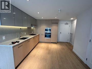Richmond apartment for rent - A modern kitchen with wooden floors and cabinets.