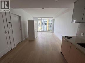 Richmond apartment for rent - A spacious kitchen with wooden flooring and a large window.