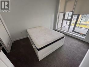 Richmond apartment for rent - A white bed with a mattress in a room with a window.