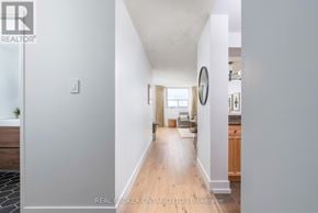 Toronto (Long Branch) condo for rent - A hallway with a round mirror on the wall.