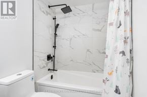 Toronto (Long Branch) condo for rent - A white bathroom with a marble wall and a shower.