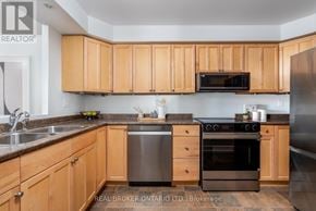 Toronto (Long Branch) condo for rent - A kitchen with wooden cabinets and stainless steel appliances.