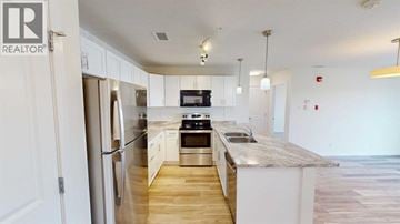 Grande Prairie apartment for rent - A kitchen with a refrigerator, stove, and sink.