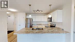 Grande Prairie apartment for rent - A kitchen with a granite countertop and white cabinets.