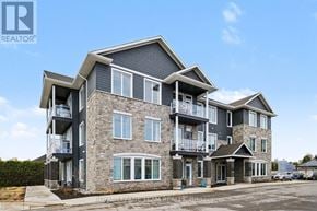 North Grenville multi-family for rent - A large, modern multi-story residential building with balconies and multiple windows.