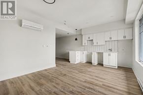 North Grenville multi-family for rent - A spacious room with wooden flooring and white walls.