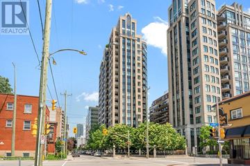 Ottawa condo for rent - A city street with a tall building in the background and a REALTOR sign in the foreground.