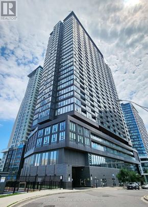 Toronto (Niagara) condo for rent - A tall building with a black fence in front of it.
