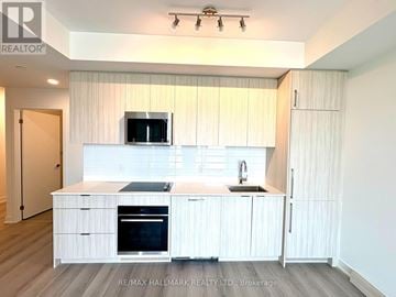 Toronto (Clairlea-Birchmount) condo for rent - A modern kitchen with white cabinets and appliances.