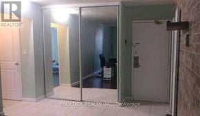 Toronto (Crescent Town) condo for rent - A room with a glass door and a white door.