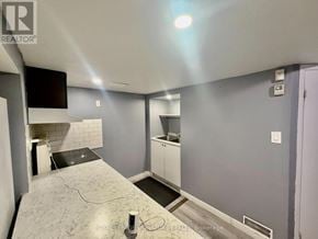 Pickering (Brock Ridge) apartment for rent - A room with a grey floor and a white wall with a black television mounted on it.