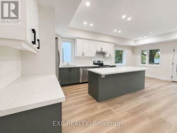 Guelph (Exhibition Park) duplex for rent - A modern kitchen with white cabinets and a large island.
