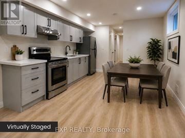 Guelph (Exhibition Park) duplex for rent - A kitchen with a table and chairs in the middle of the room.