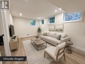 Guelph (Exhibition Park) duplex for rent - A living room with a white couch, a coffee table, and a flat screen TV.