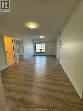Windsor condo for rent - A long hallway with wood floors and white walls.