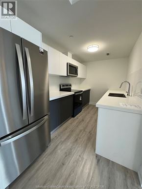 Windsor condo for rent - A kitchen with a stainless steel refrigerator and a white counter top.