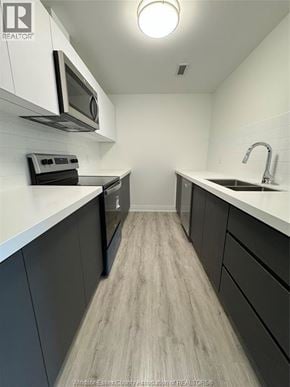 Windsor condo for rent - A kitchen with dark wood cabinets and white countertops.