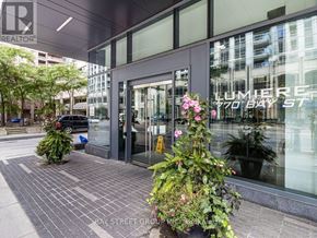 Toronto (Bay Street Corridor) condo for rent - The front of a building with the sign "LUMBER REALTOR" on the window.