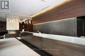 Toronto (Bay Street Corridor) condo for rent - A reception area with a fireplace and a receptionist.