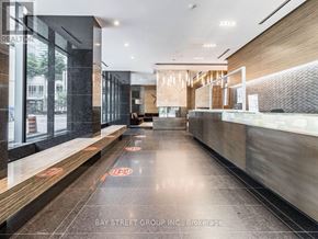 Toronto (Bay Street Corridor) condo for rent - A hallway with a wooden floor and a glass wall on the left side.