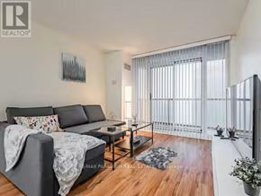 Toronto (Waterfront Communities) condo for rent - A living room with a grey sofa and a wooden floor.