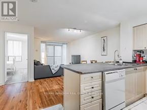 Toronto (Waterfront Communities) condo for rent - A kitchen with wooden floors and white appliances.