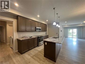 Kitchener townhouse for rent - A modern kitchen with brown cabinets and a granite countertop.