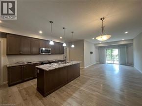 Kitchener townhouse for rent - A well-lit kitchen with wooden cabinets and a central island.