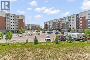 Windsor condo for rent - A parking lot with cars and apartment buildings in the background.