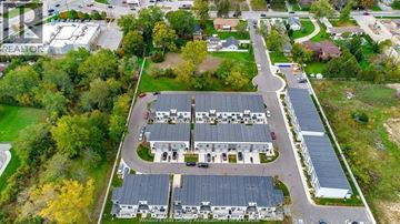 Windsor townhouse for rent - An aerial view of a large building surrounded by trees and a parking lot.