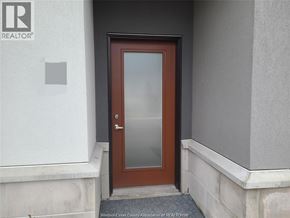 Windsor townhouse for rent - A brown door with a glass panel is set in a white wall.