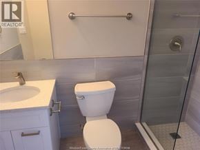 Windsor townhouse for rent - A white toilet in a bathroom with a glass shower door.