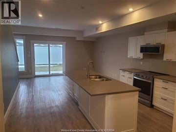 Windsor townhouse for rent - A kitchen with white cabinets and a wooden floor.