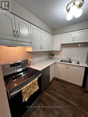Welland (Prince Charles) condo for rent - A kitchen with white cabinets and a black stove top oven.