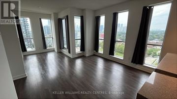 Toronto (Regent Park) condo for rent - A living room with a couch and a table in front of a window with a city view.
