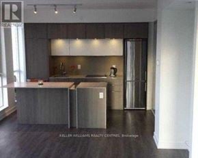 Toronto (Regent Park) condo for rent - A modern kitchen with a large island and stainless steel appliances.