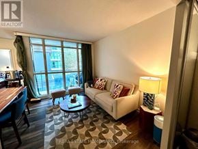Toronto (Waterfront Communities) condo for rent - A living room with a couch, coffee table, and a window with a view of a building.