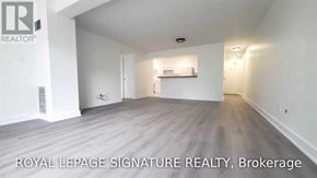 Toronto (Bay Street Corridor) condo for rent - A spacious room with wooden flooring and white walls, labeled as a brokerage by Royal LePage Signature Realty.