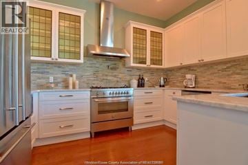 Windsor condo for rent - A kitchen with white cabinets and a stainless steel refrigerator.