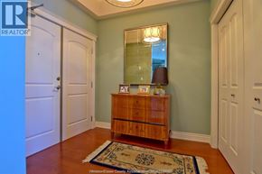 Windsor condo for rent - A room with a wooden chest of drawers and a mirror above it.