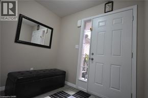 Kitchener townhouse for rent - A white door is in a room with a black bench and a mirror.