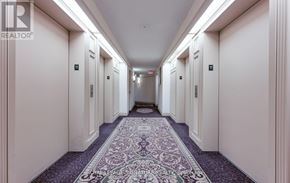 Mississauga (Hurontario) condo for rent - A long hallway with a carpeted floor and doors on both sides.