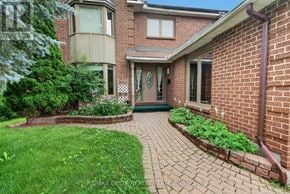 Ottawa apartment for rent - A brick house with a green lawn and a small garden in front.
