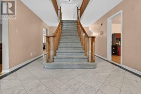 Ottawa apartment for rent - A hallway with a staircase and a brokerage logo.