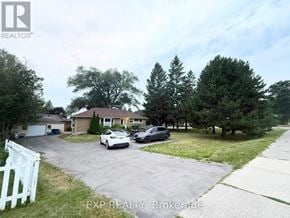 Whitchurch-Stouffville (Stouffville) apartment for rent - A white picket fence marks the entrance to a residential driveway.