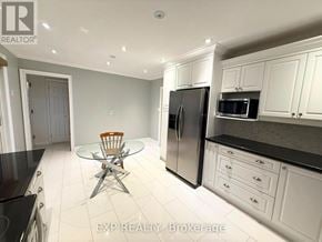 Whitchurch-Stouffville (Stouffville) apartment for rent - A kitchen with white cabinets and black countertops.