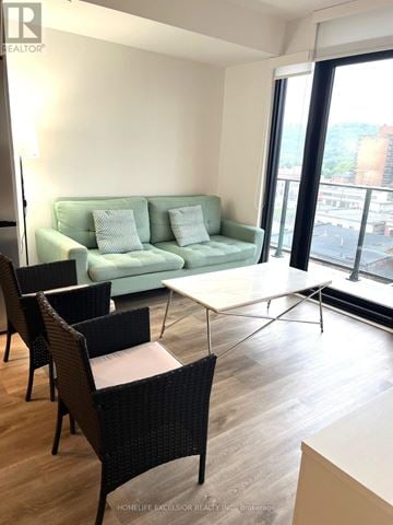 Hamilton (Beasley) condo for rent - A living room with a green couch and a white coffee table.