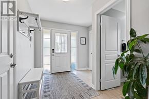 Pelham (Fonthill) apartment for rent - A white hallway with a rug on the floor and a plant on the right side.