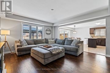 Pelham (Fonthill) apartment for rent - A well-lit, spacious living room with a grey sofa set and a large bed in the center.